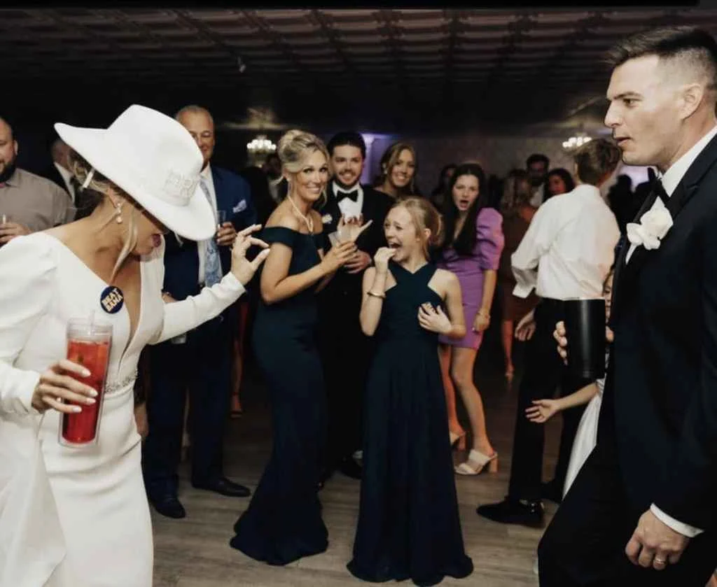 A woman in a black dress dances with friends at Magnolia Valley Weddings & Events wedding.