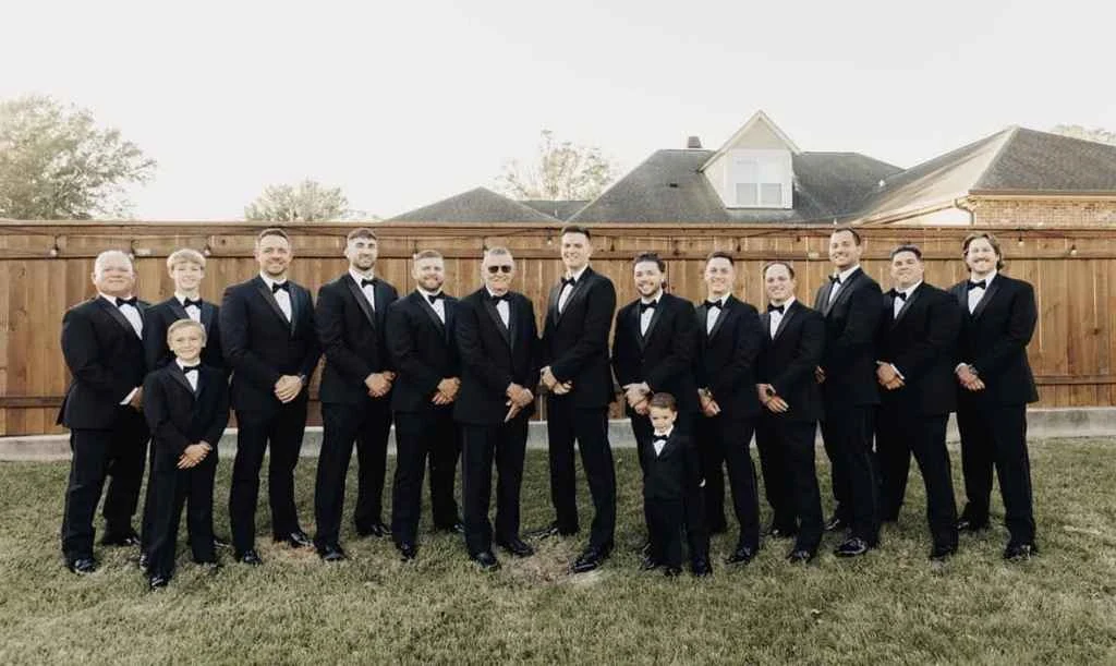 Magnolia Valley Weddings & Events group of men in tuxedos pose at the wedding venue.