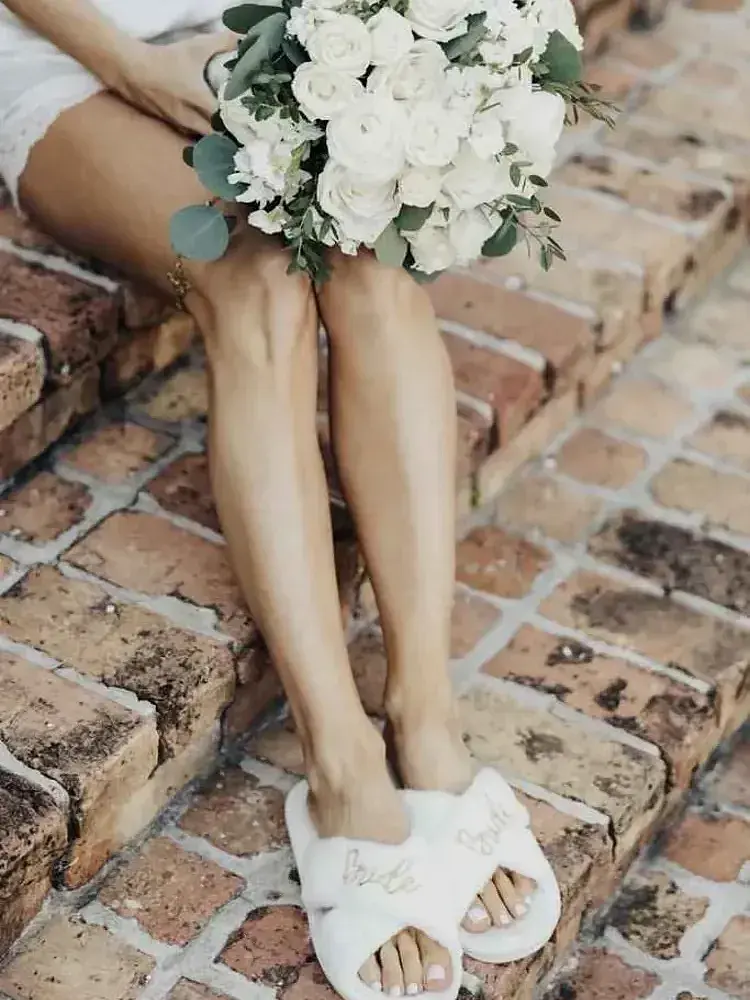 Magnolia Valley Weddings & Events bride’s feet with white flowers and greenery are captured in detail.